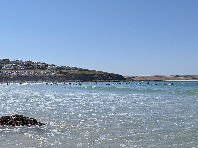 Surfers hanging out in the sea waiting for the waves at Polzeath