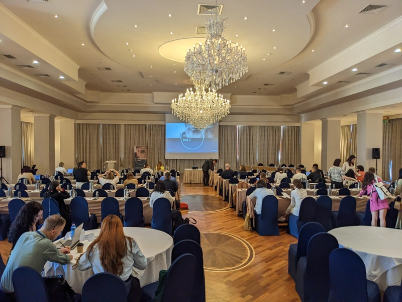 Grand Ballroom with three chandeliers with the screen at the back showing the slides