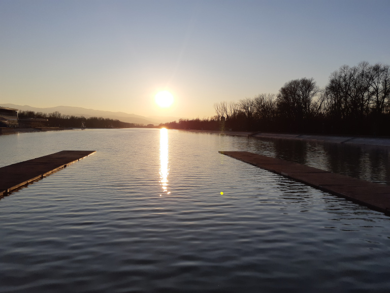 Sun setting over a long rowing canal