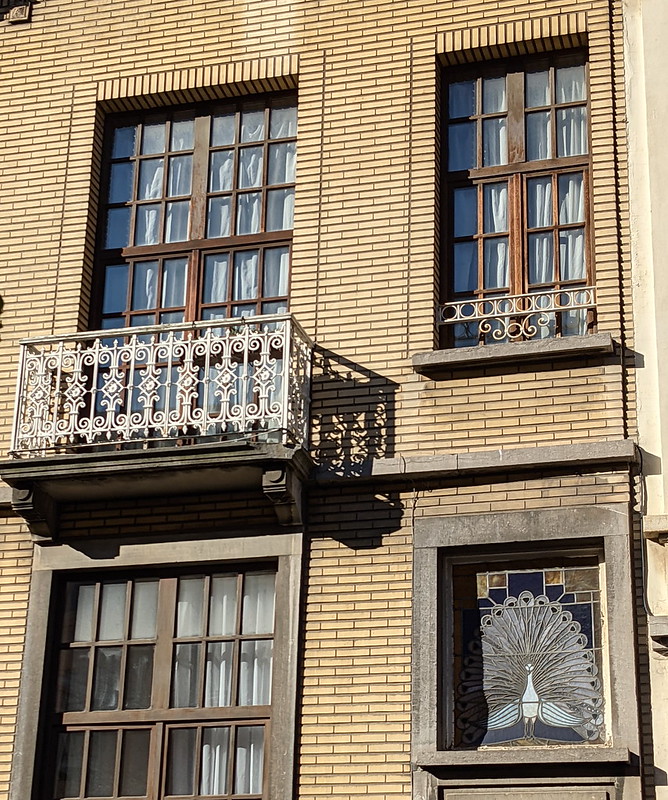 Townhouse façade with peacock stained glass windows