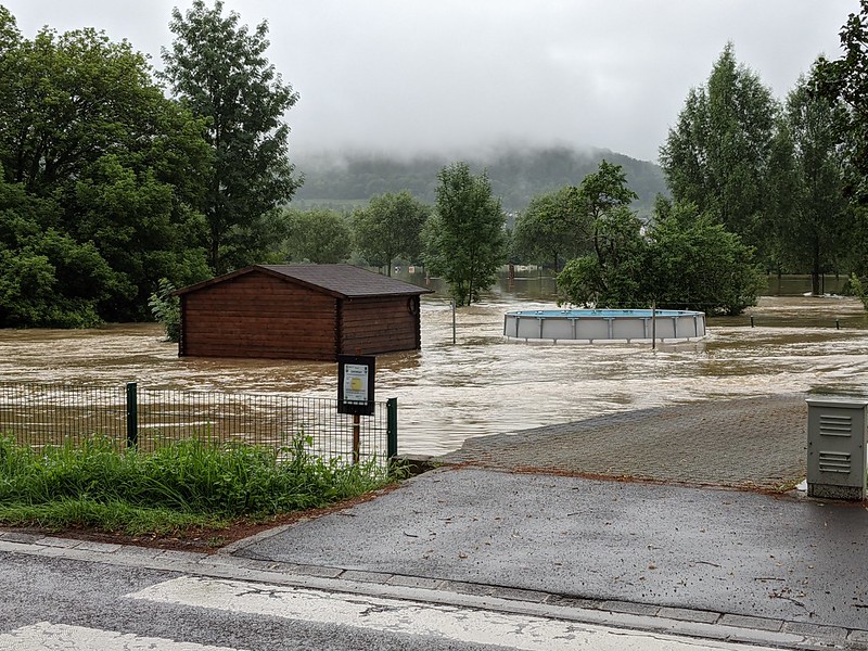 Flooded garden with shed and pool surrounded by water