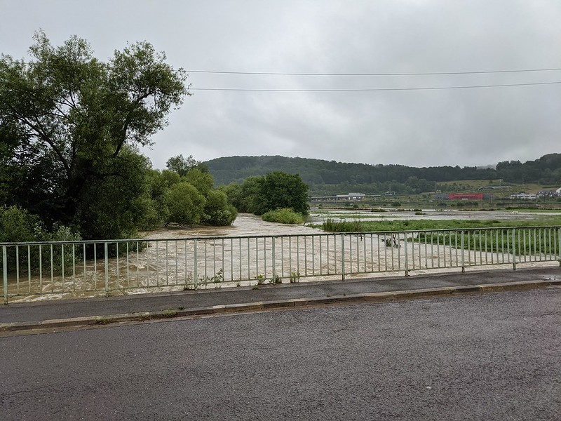 Flooded river rushing under bridge