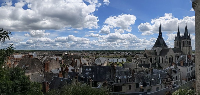 Panoramic view of the city of Blois, with the roof tops in the foreground, the cathedral to the right and the river Seine in the background 