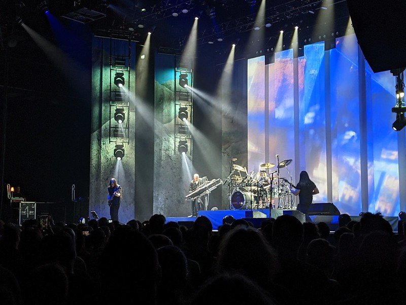 Dream Theatre on stage with a blue and green bakdrop and the keyboard rotated up at one end to be at heavy angle