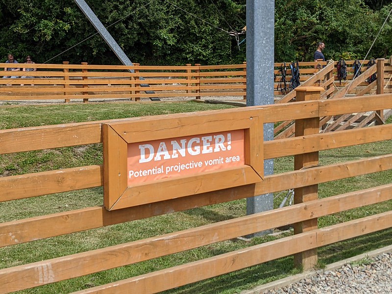 Sign in front of an activity reading "DANGER! Potential projective vomit area".