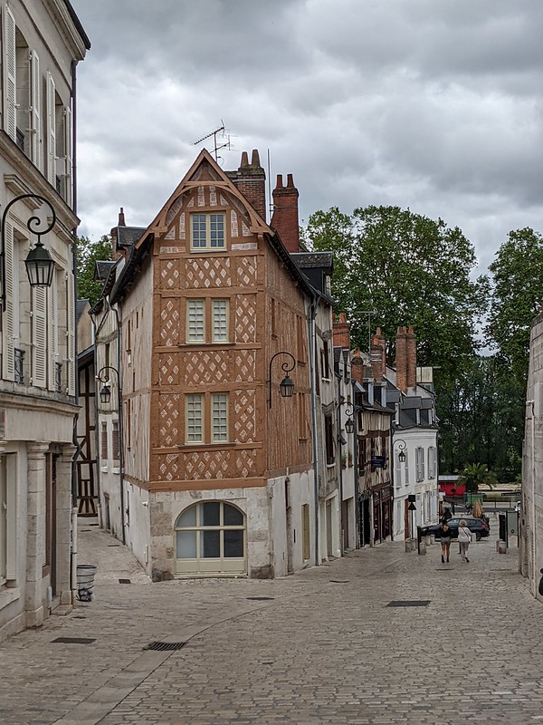 An old restored house in Orleans, with orange brown wooden beams in it's structure.