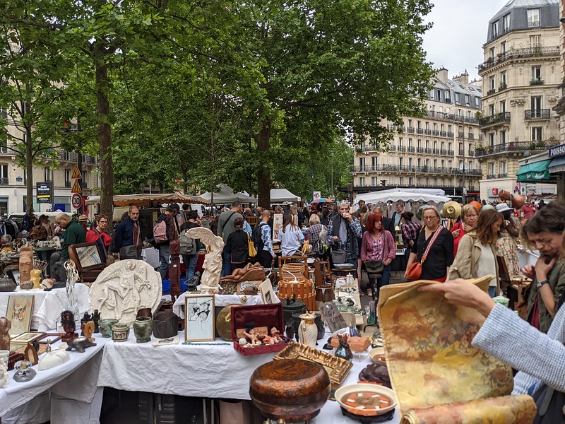 Flea market with tables full of bric-a-brac.