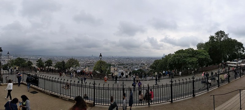 Panoramic view of Paris under a dark grey cloud.