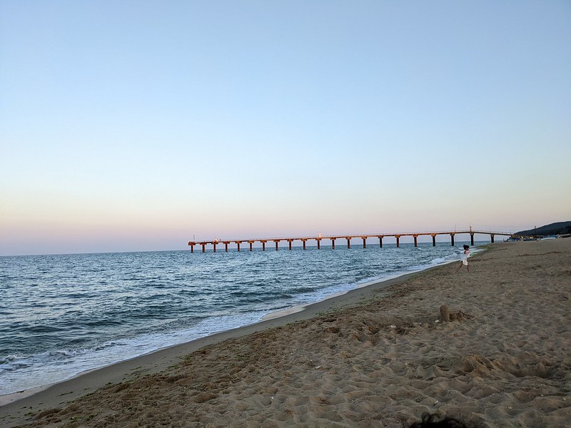 A pier reaching out into the sea at sunset