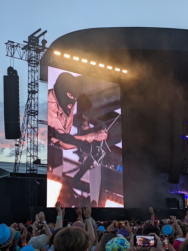 Tyler Joseph free climbing up the scaffolding of the main stage