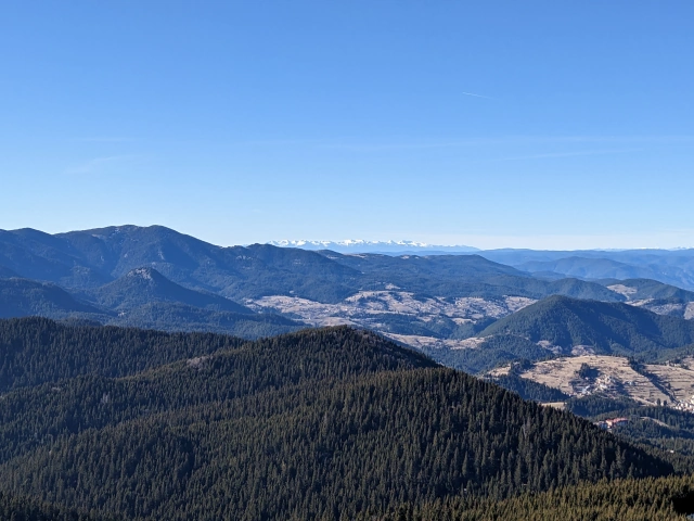 View over the snowless mountains from the top of the tower. In the far distance there are snow topped mountains