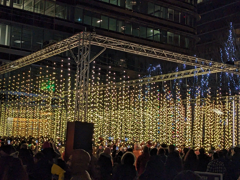 Small lights hanging from ropes arranged in a square viewed from outside