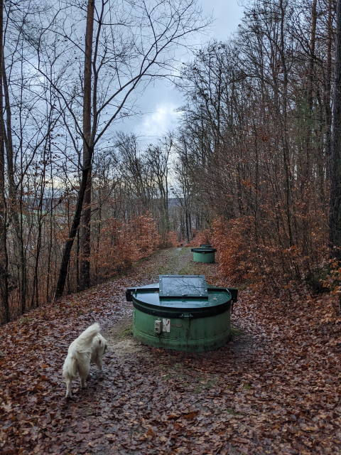 Round green metal structures covering an old well system allong path