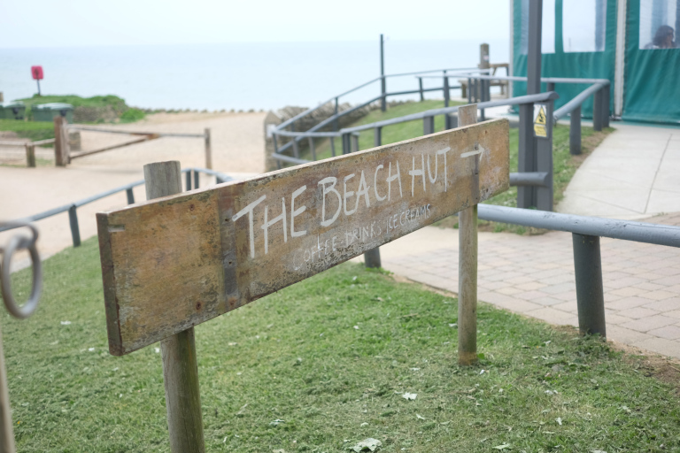 Sign saying the beach hut, overlooking the beach