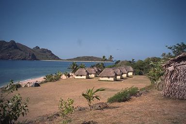 Huts on a ledge overlooking the beach and sea on a small island